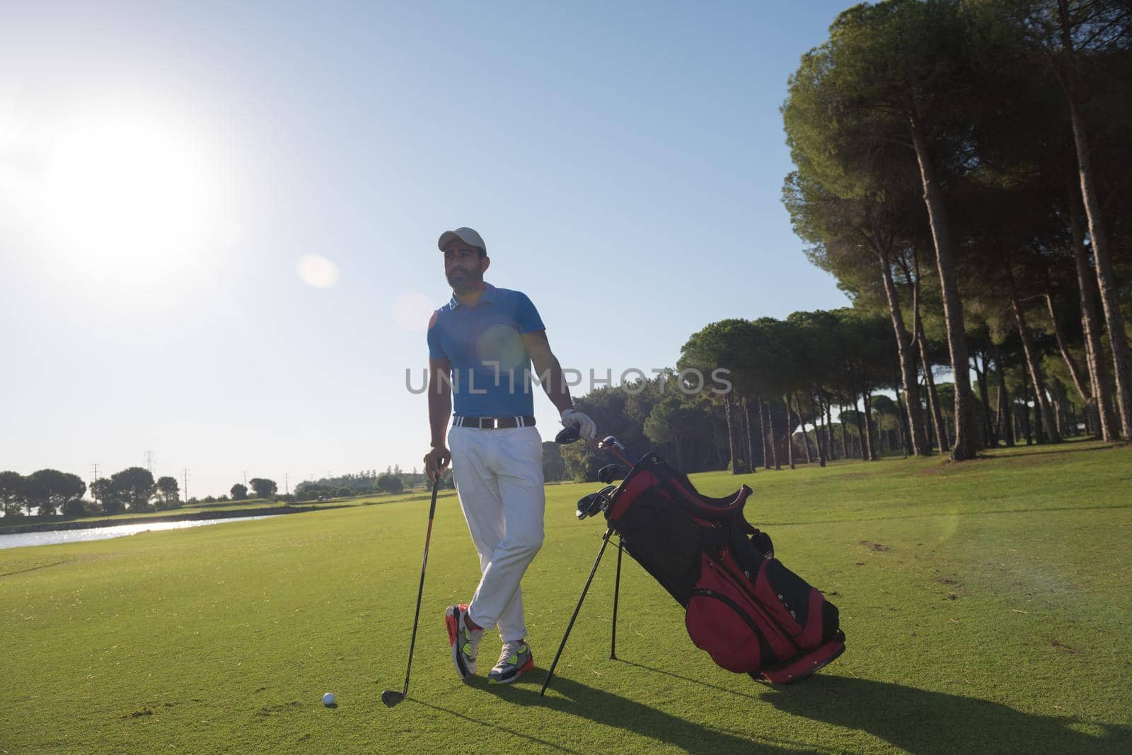 handsome middle eastern golf player portrait at course on beautiful sunset in backgeound