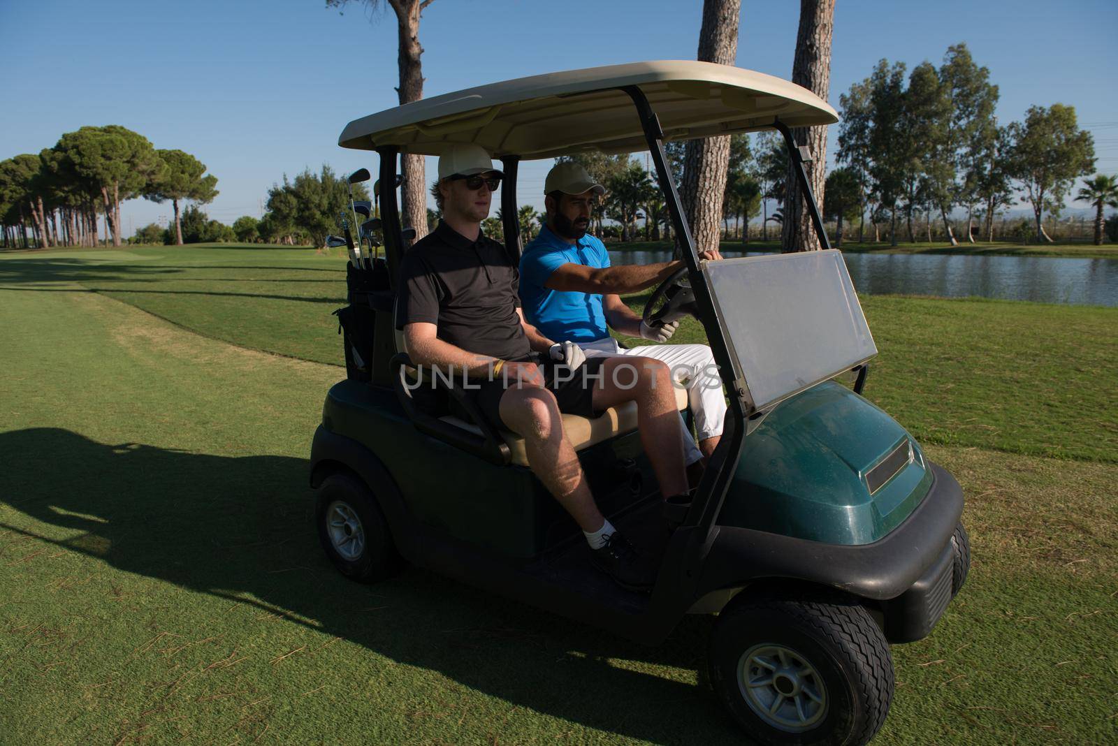 golf players driving cart at course on beautiful morning sunrise. friends together have fun and relax on vacation.