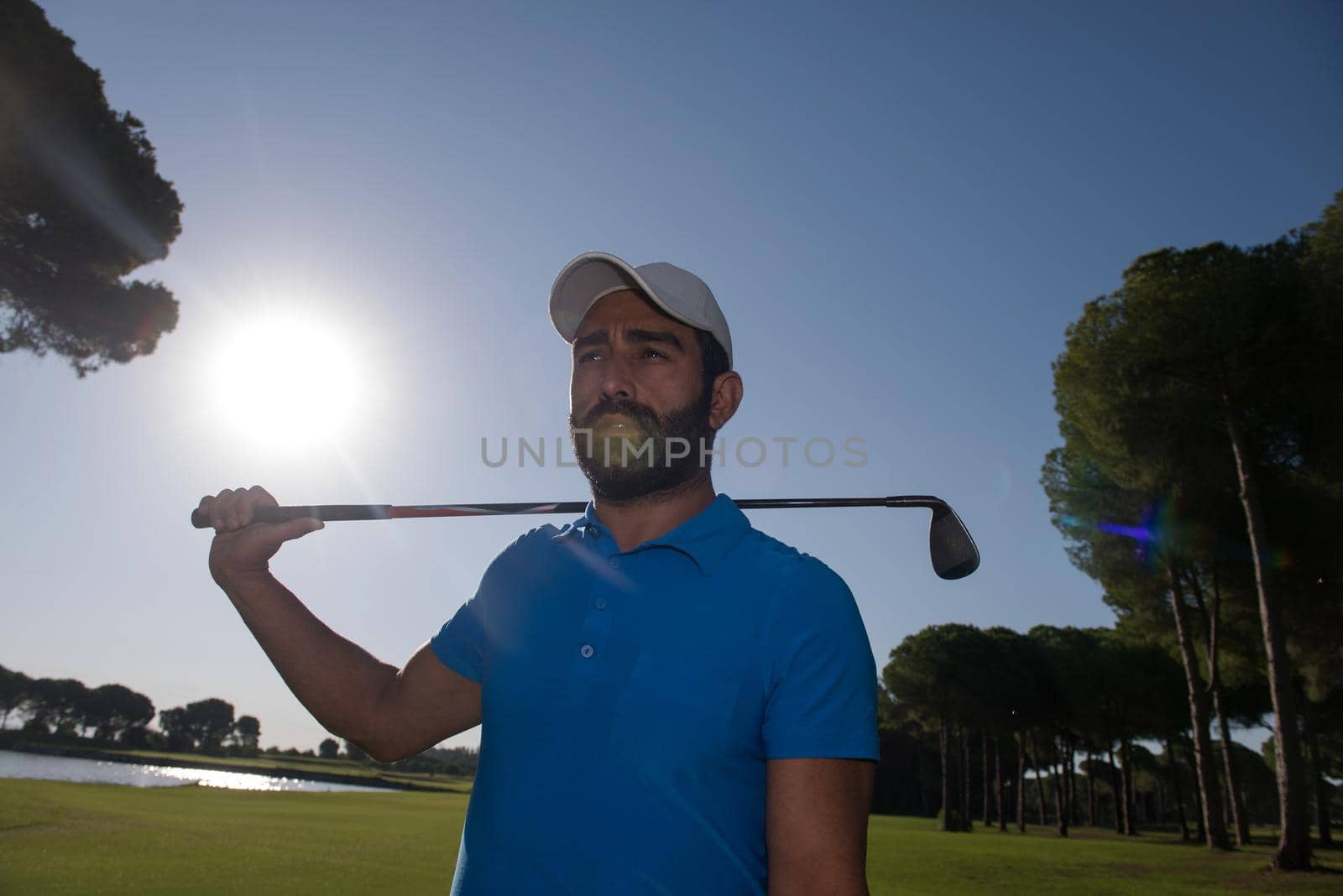 handsome middle eastern golf player portrait at course on beautiful sunset in backgeound