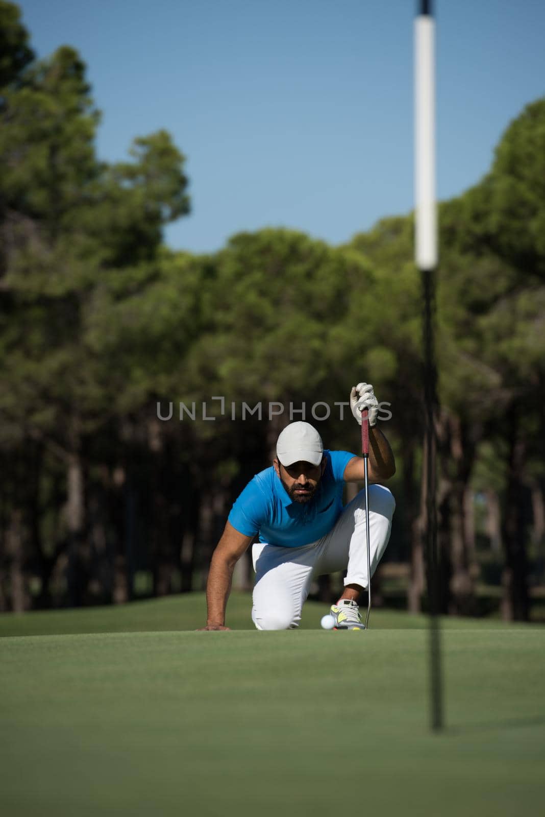 golf player aiming shot with club on course at beautiful sunny day