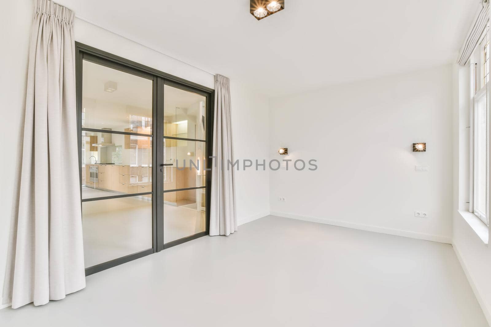 Large white room with sliding glass doors in a black frame