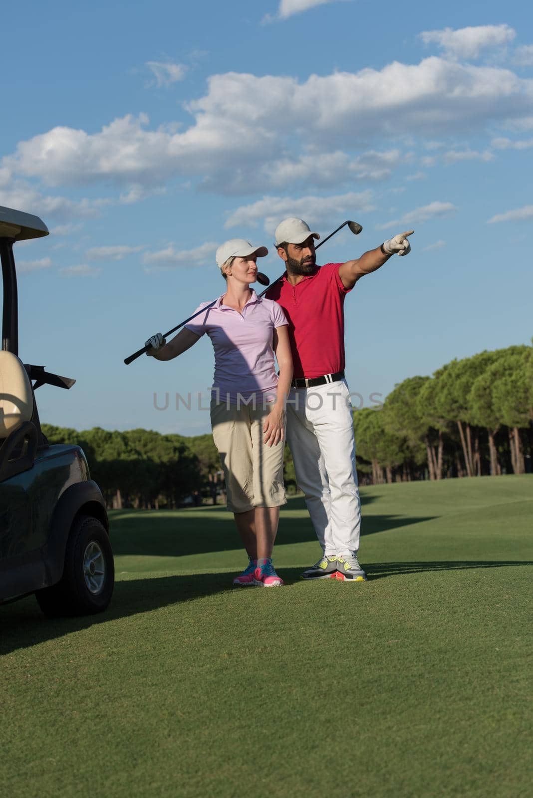 portrait of happy young  golfers couple on golf course