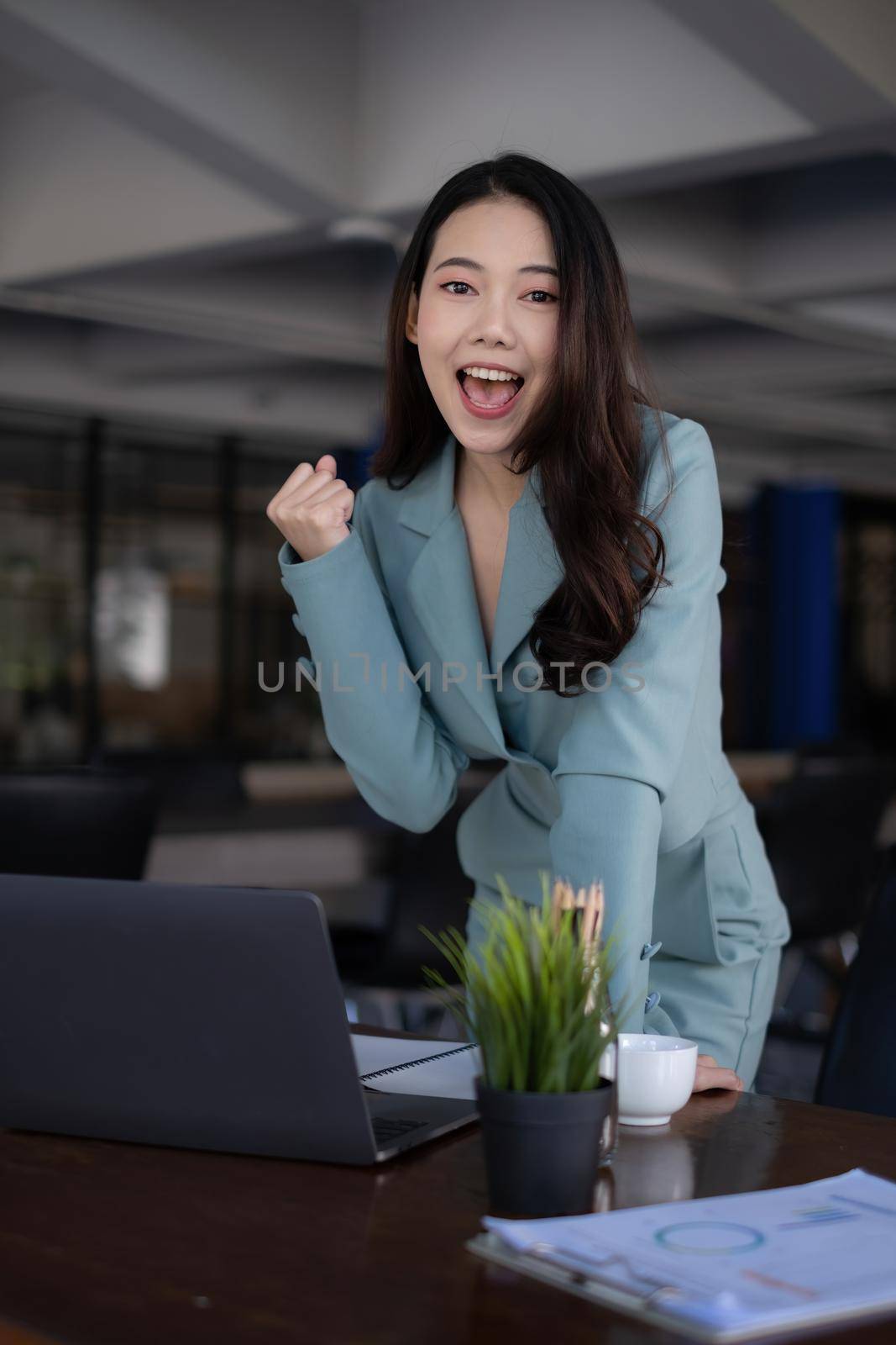 Excited asian business woman and celebrating success and video call with her business team. Finance, tax, fund, account concept. by itchaznong