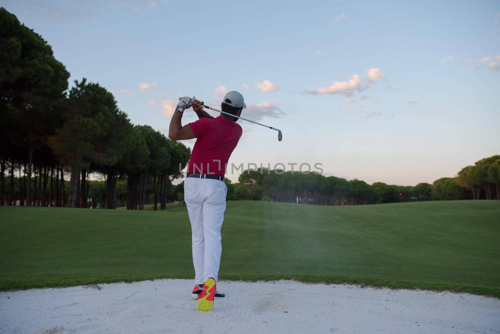 golfer hitting a sand bunker shot on sunset by dotshock