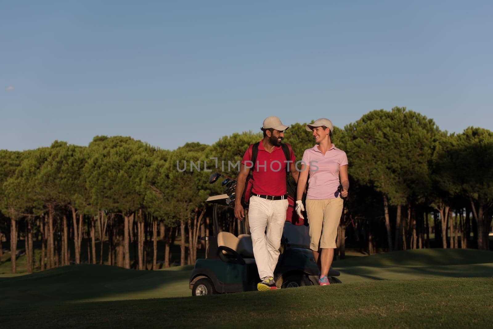 couple walking on golf course by dotshock