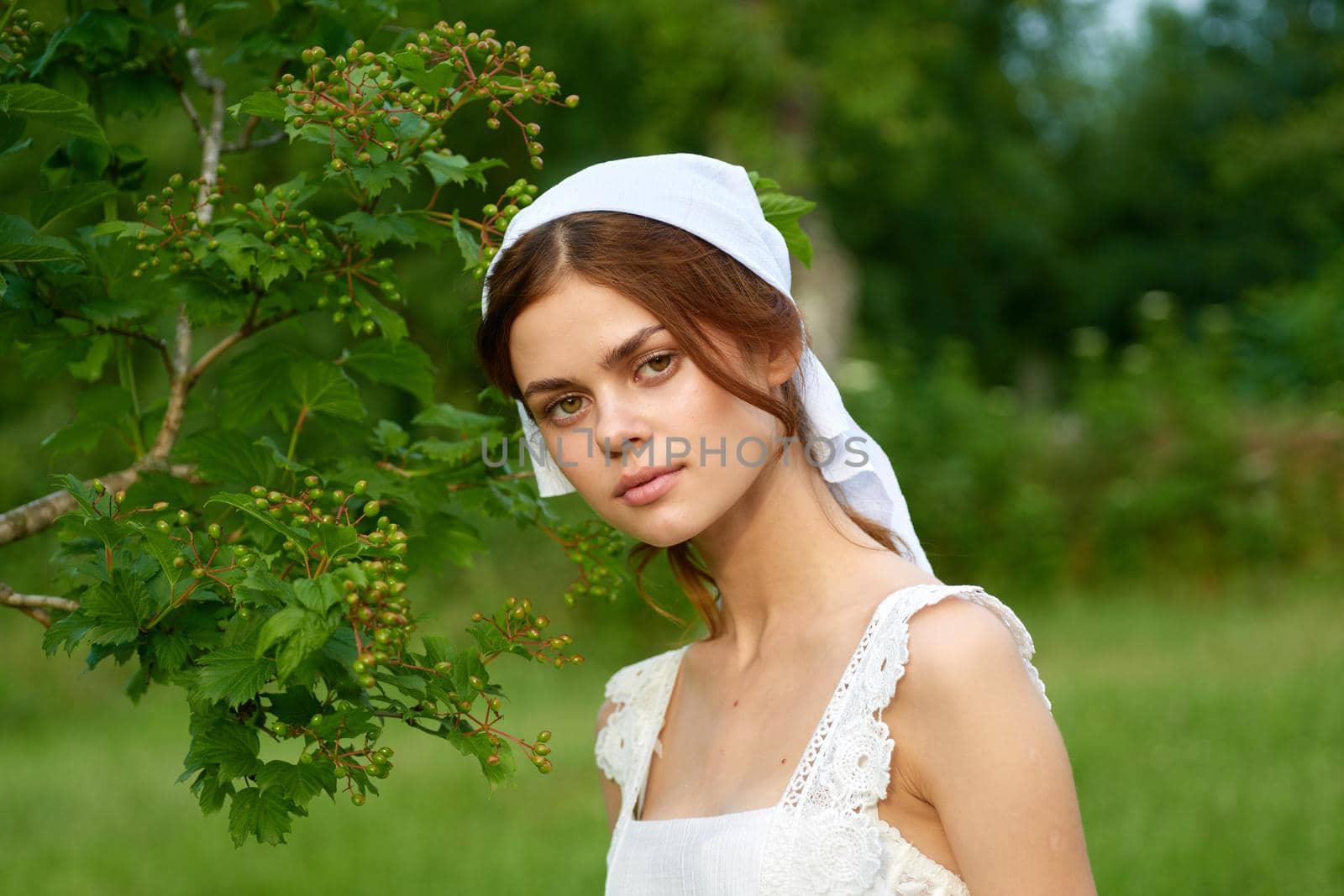 Woman in white dress in the village outdoors Green grass Farmer. High quality photo