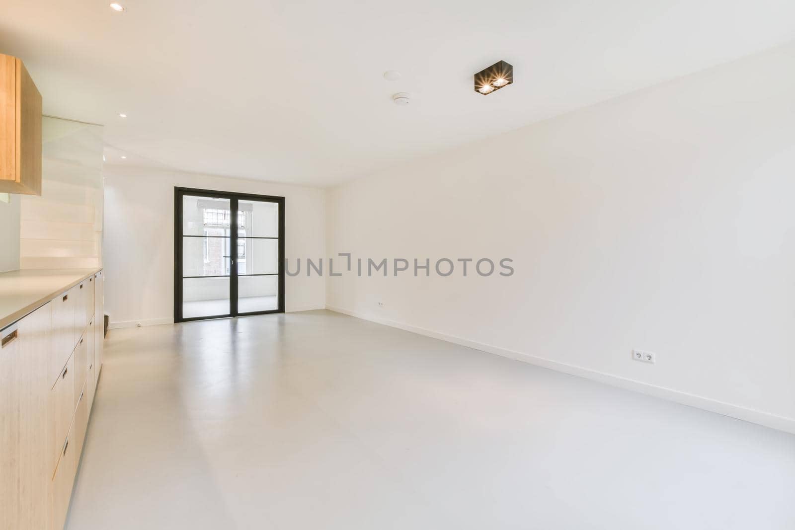 Large white room with sliding glass doors in a black frame