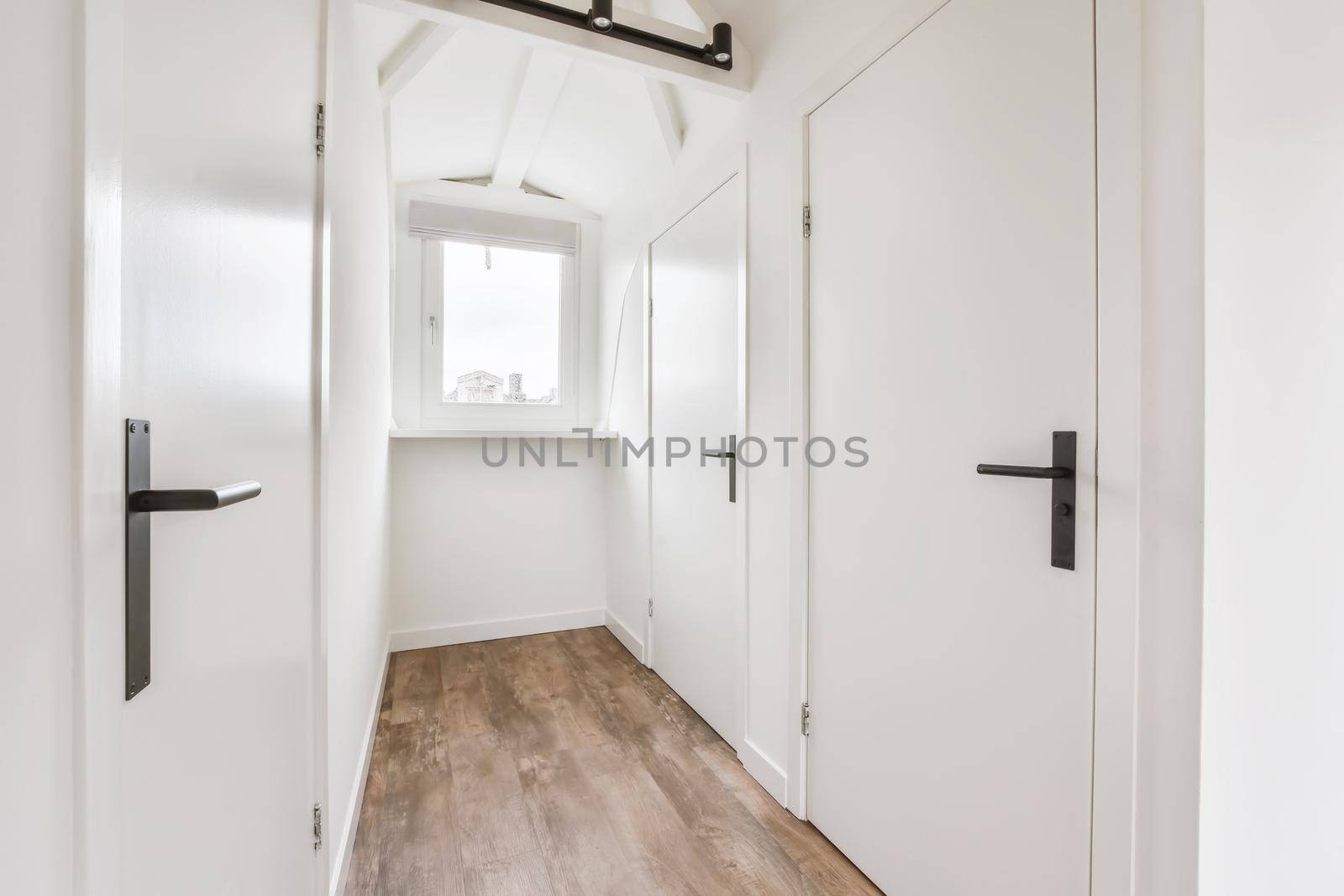 Stunning hallway with dark parquet floors and white walls