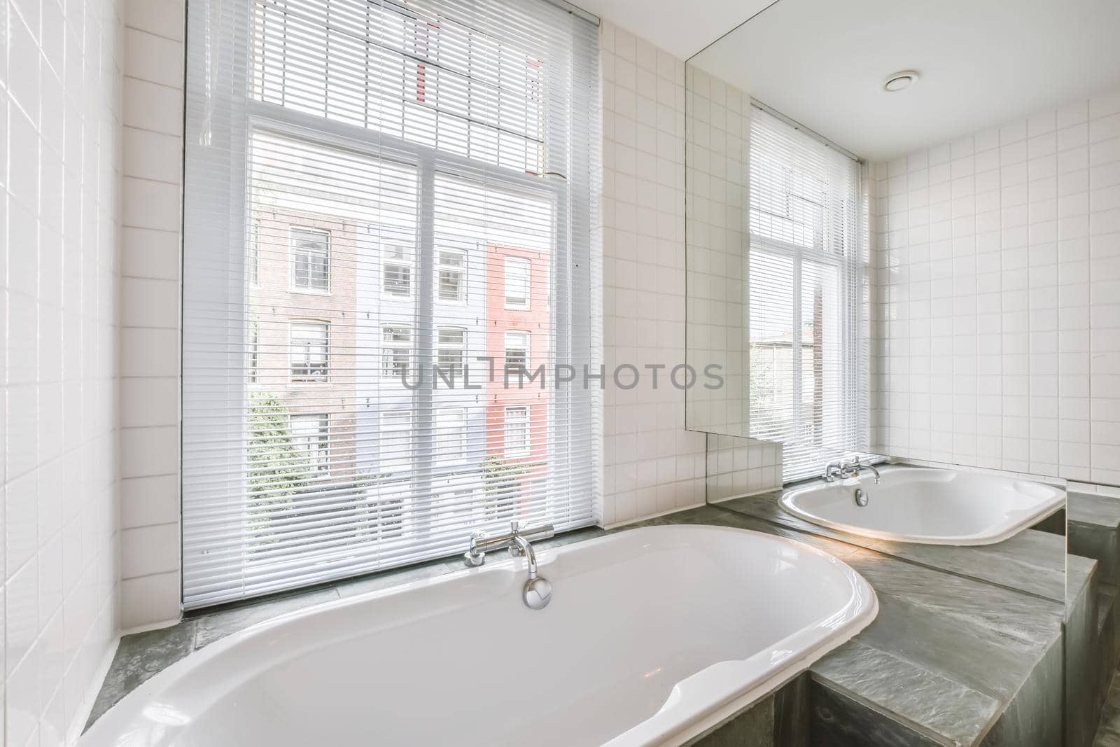 Luxurious bathroom with marble floor and bathtub near the window