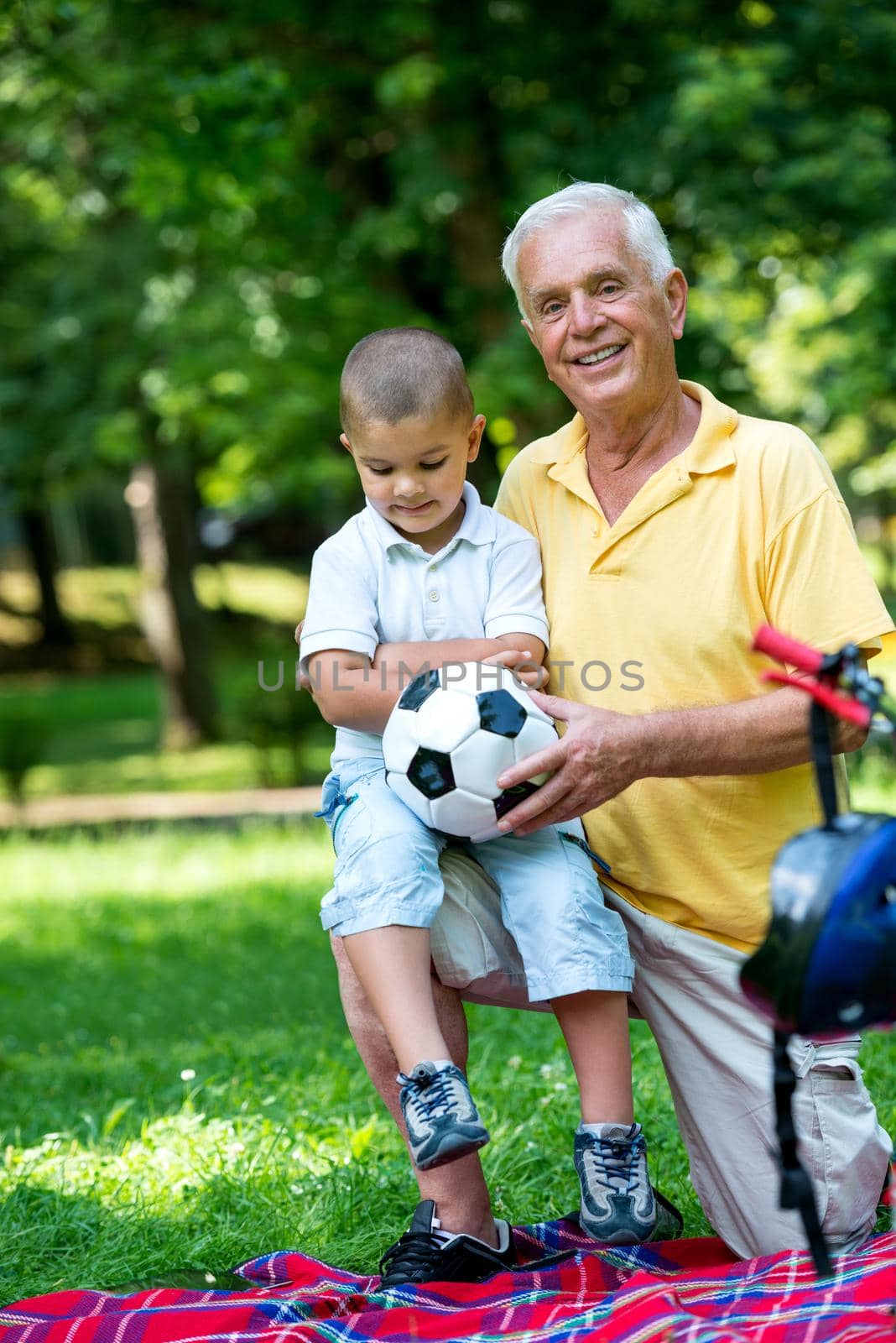 happy grandfather and child have fun and play in park on beautiful  sunny day