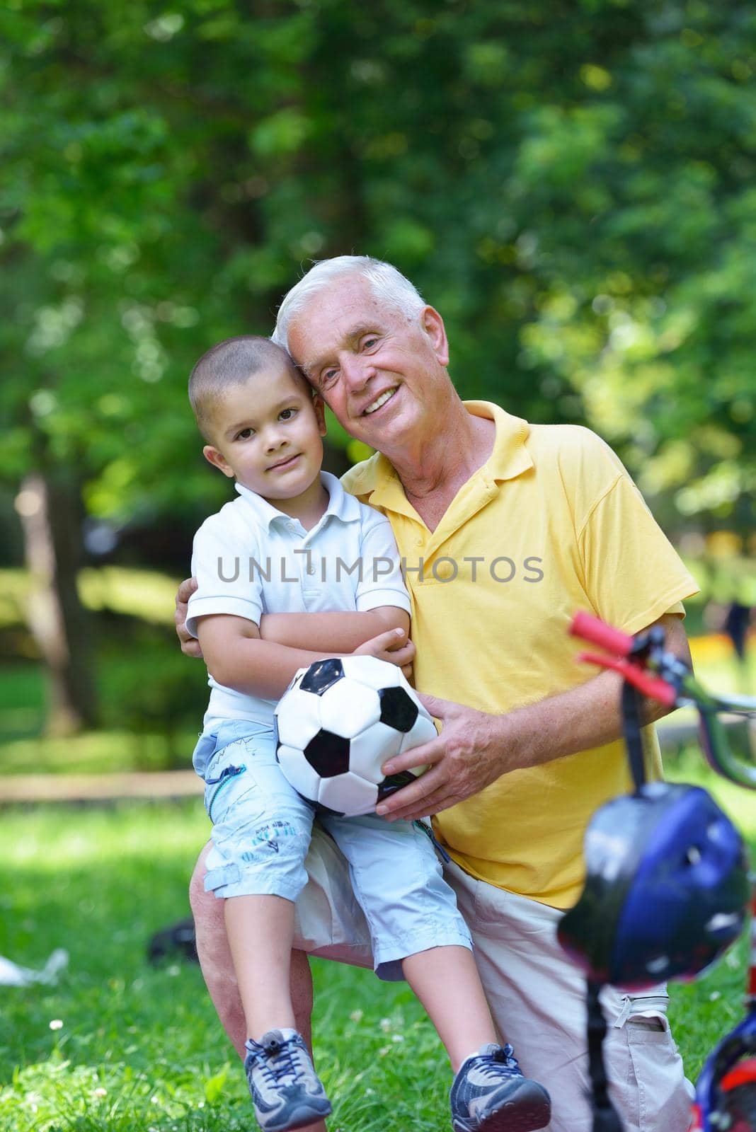 happy grandfather and child have fun and play in park