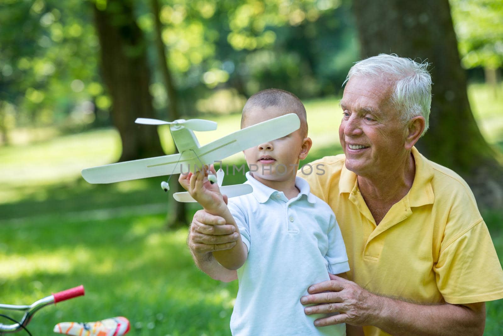 happy grandfather and child have fun and play in park on beautiful  sunny day