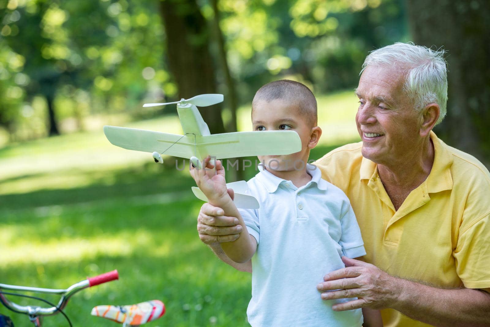 happy grandfather and child have fun and play in park on beautiful  sunny day