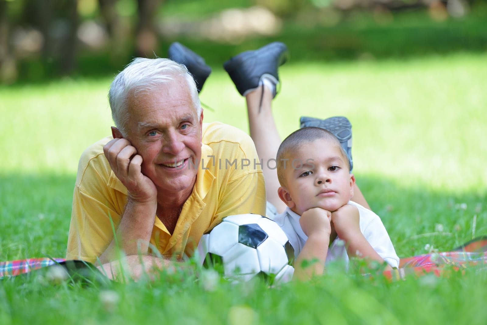 happy grandfather and child have fun and play in park