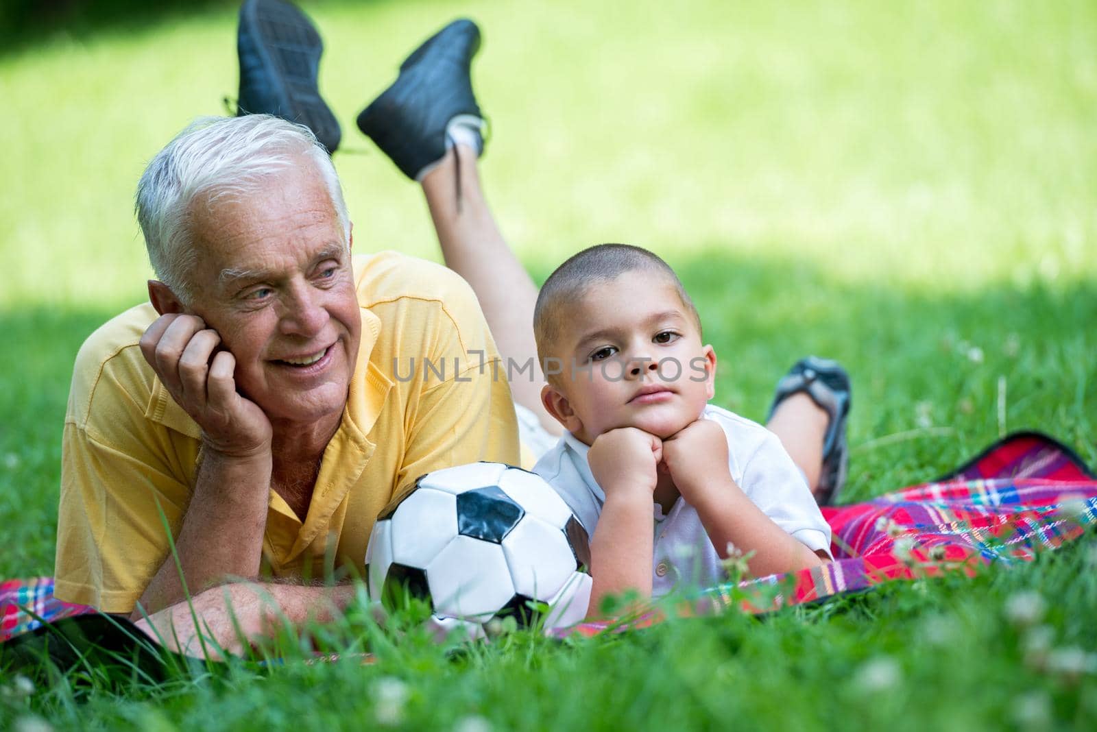 happy grandfather and child have fun and play in park on beautiful  sunny day