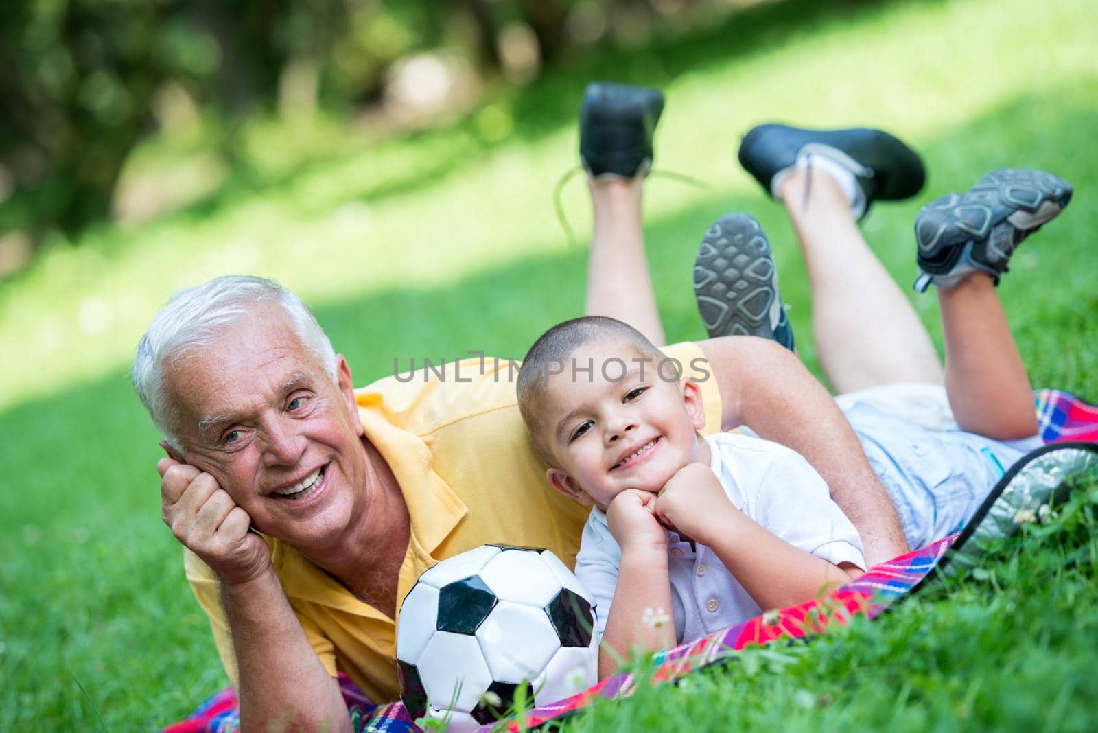 happy grandfather and child have fun and play in park on beautiful  sunny day