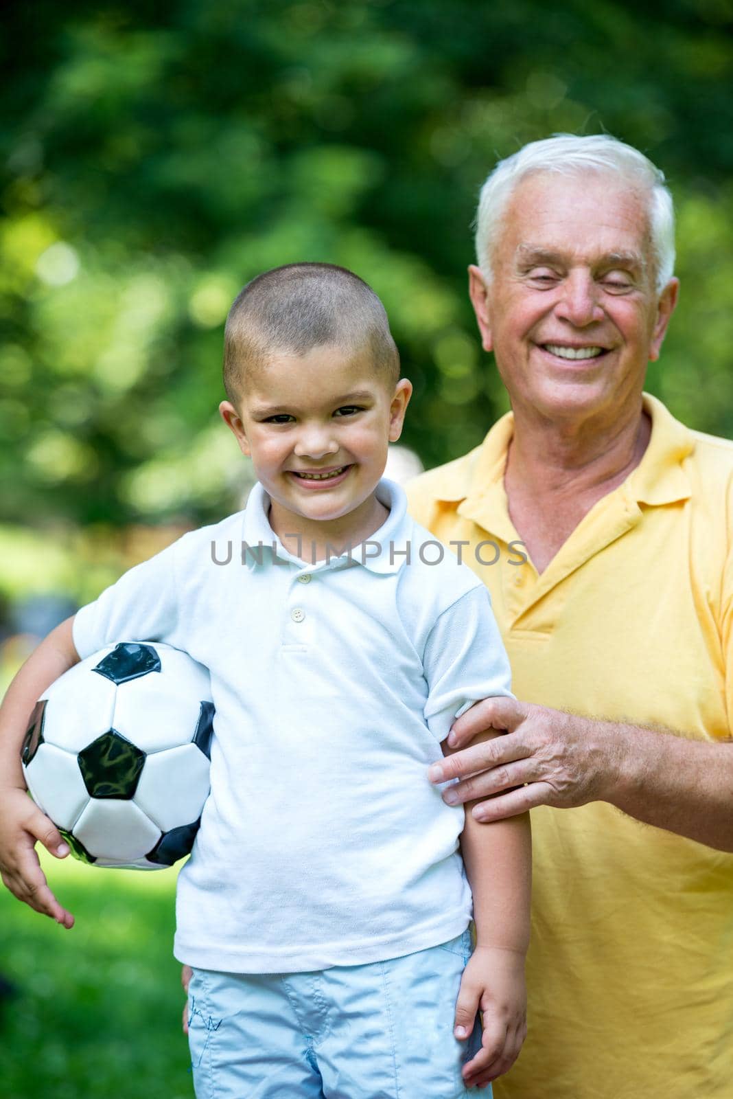 happy grandfather and child have fun and play in park on beautiful  sunny day