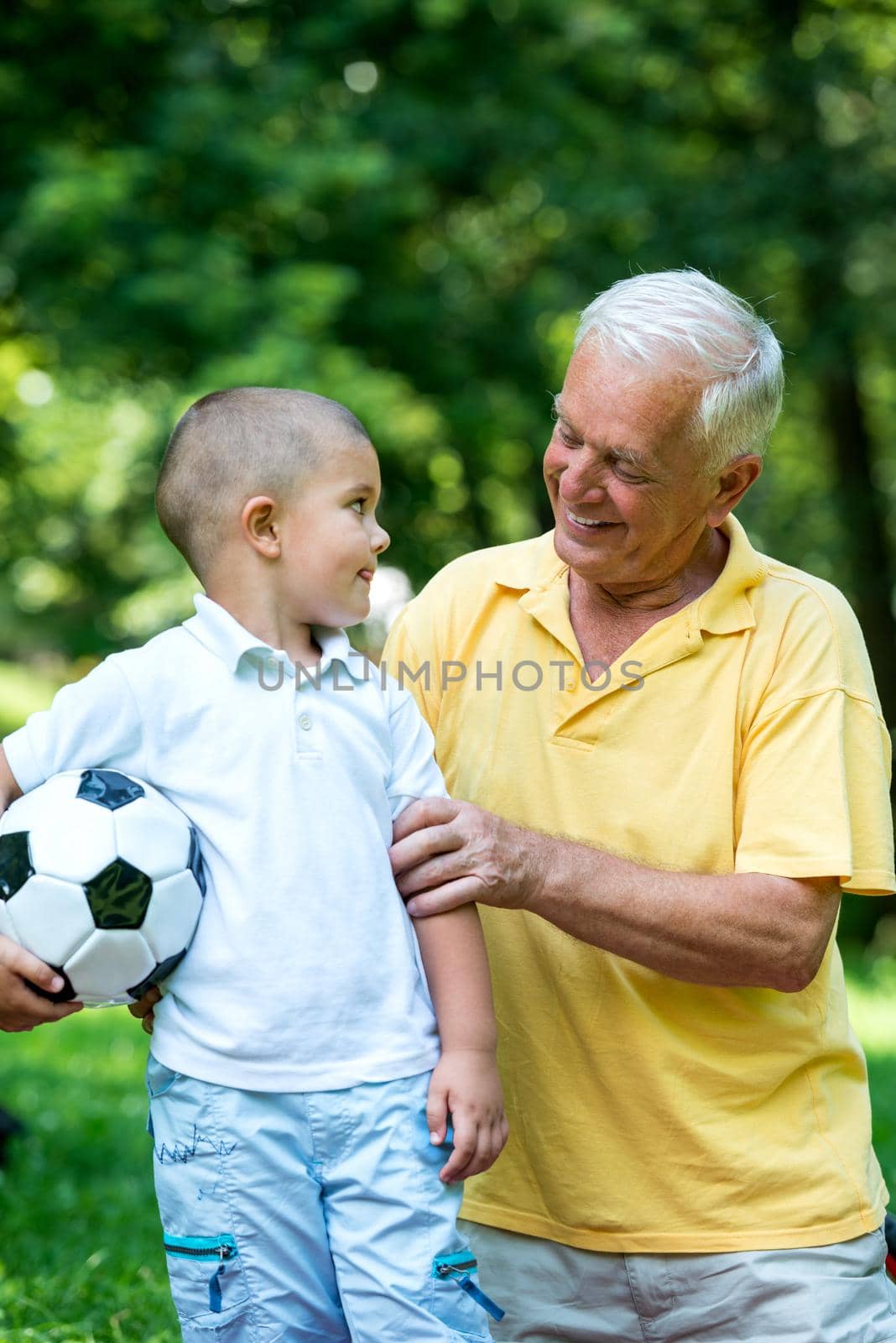 happy grandfather and child have fun and play in park on beautiful  sunny day