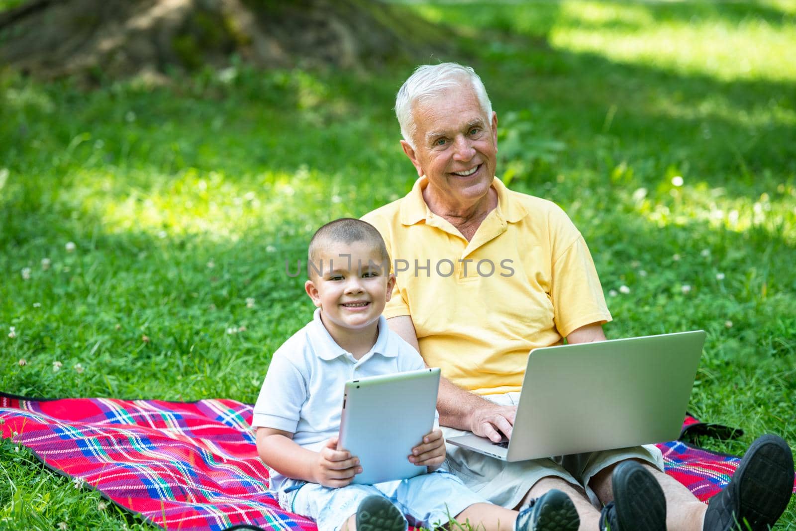 grandfather and child using laptop by dotshock