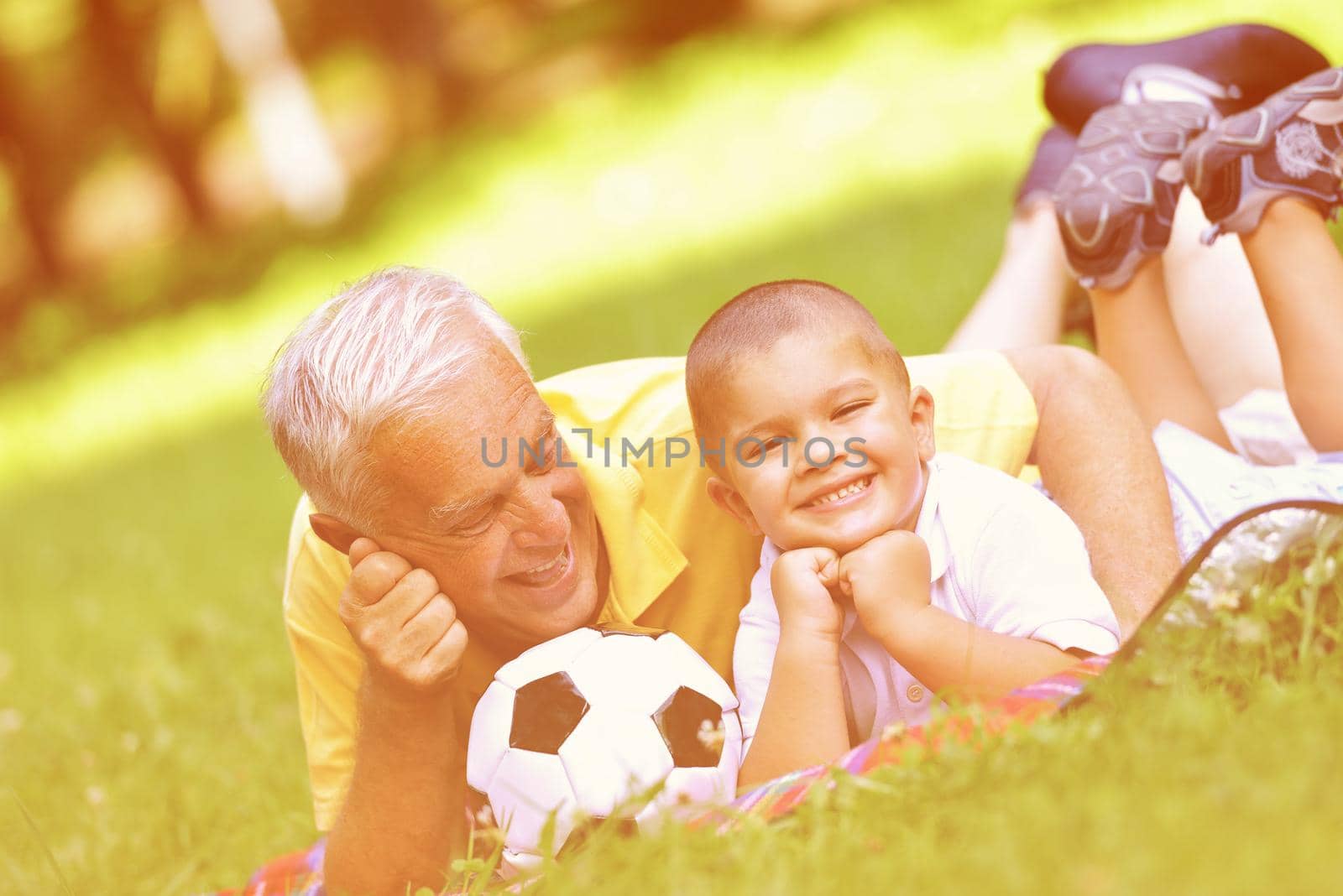 happy grandfather and child have fun and play in park