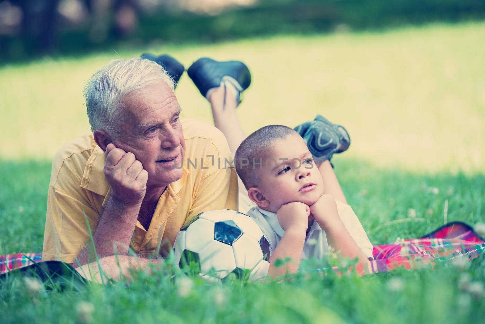 happy grandfather and child have fun and play in park on beautiful  sunny day