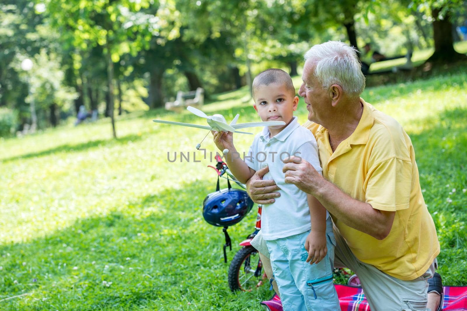 happy grandfather and child have fun and play in park on beautiful  sunny day