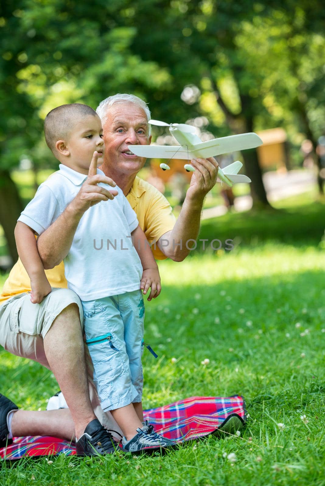 happy grandfather and child have fun and play in park on beautiful  sunny day