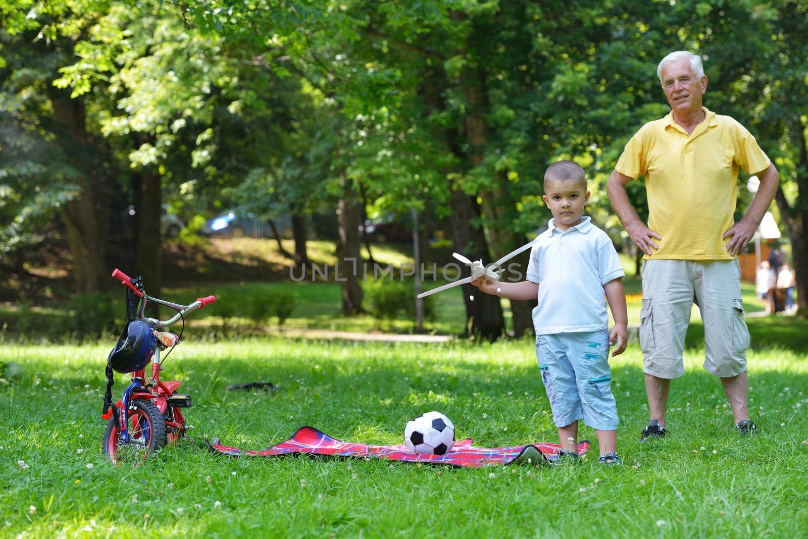 happy grandfather and child have fun and play in park