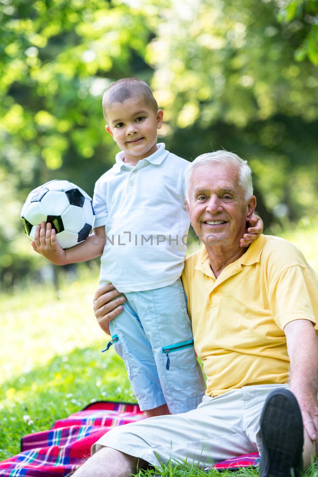 happy grandfather and child have fun and play in park on beautiful  sunny day