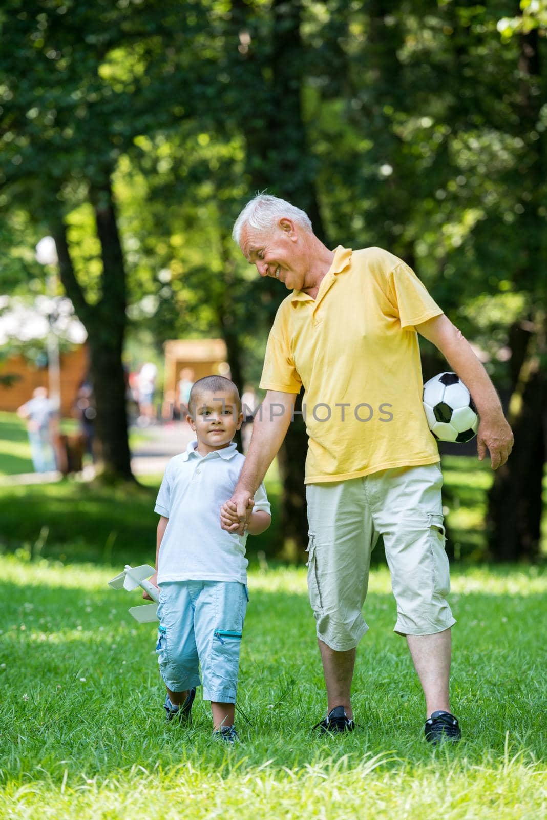 happy grandfather and child have fun and play in park on beautiful  sunny day