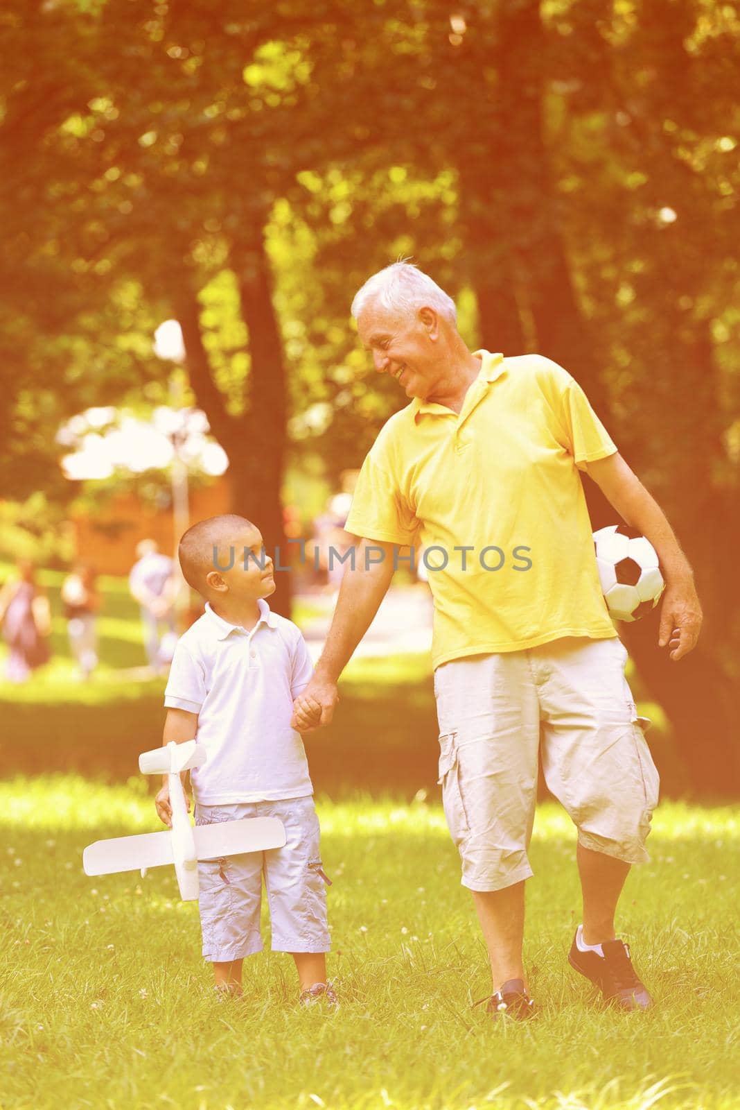 happy grandfather and child have fun and play in park