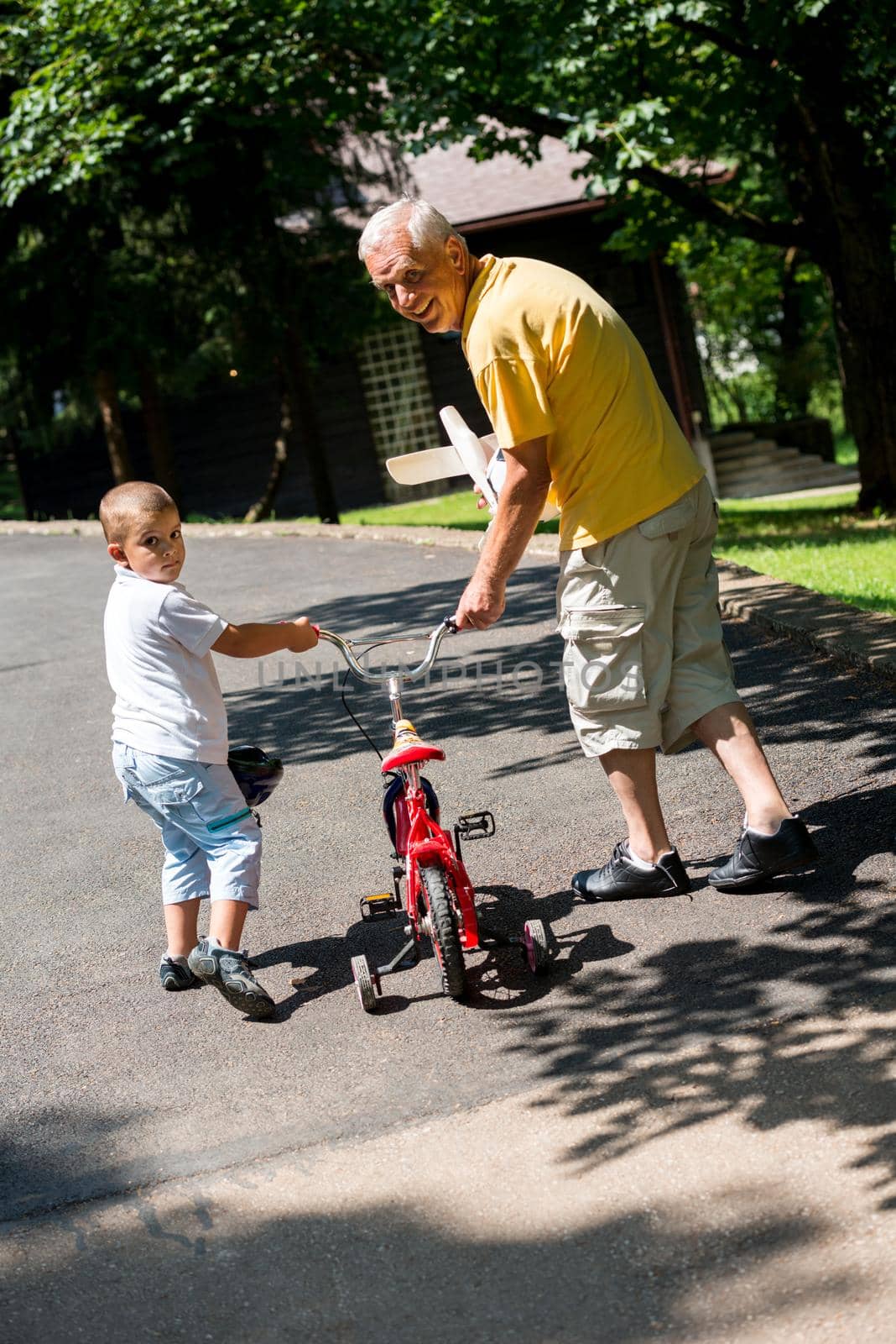 happy grandfather and child have fun and play in park on beautiful  sunny day