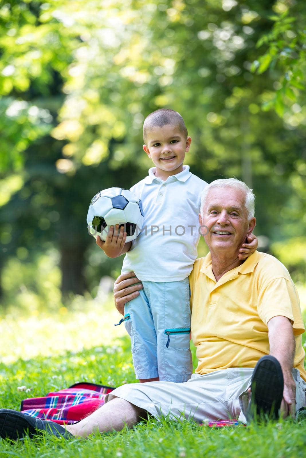 happy grandfather and child have fun and play in park on beautiful  sunny day