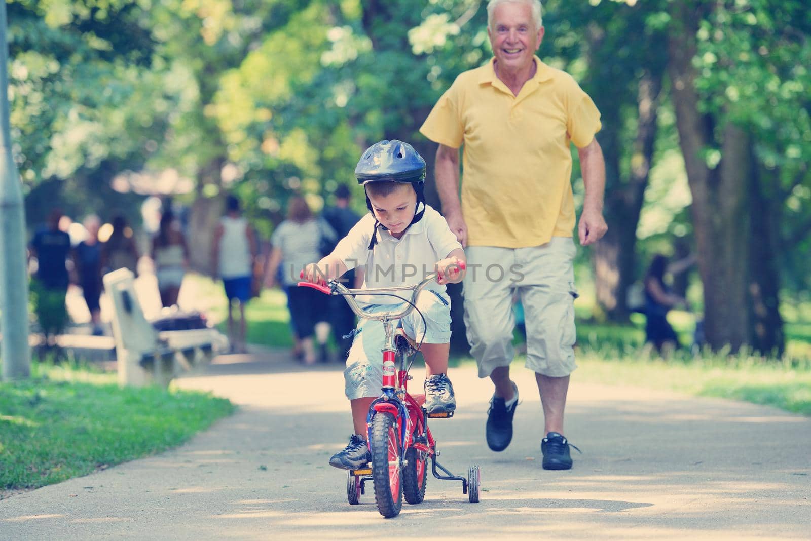 happy grandfather and child have fun and play in park