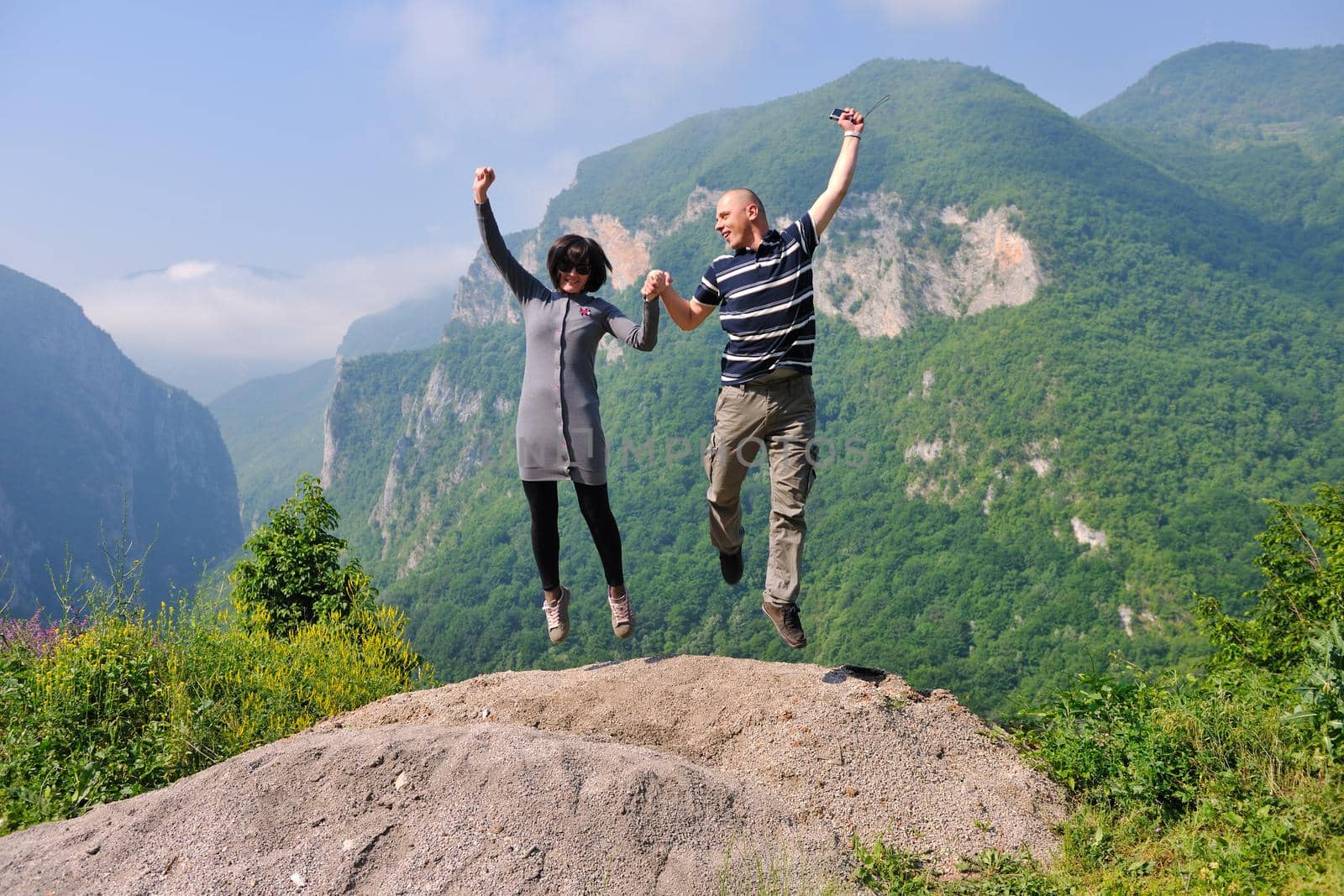 happy young couple jumping in the air by dotshock