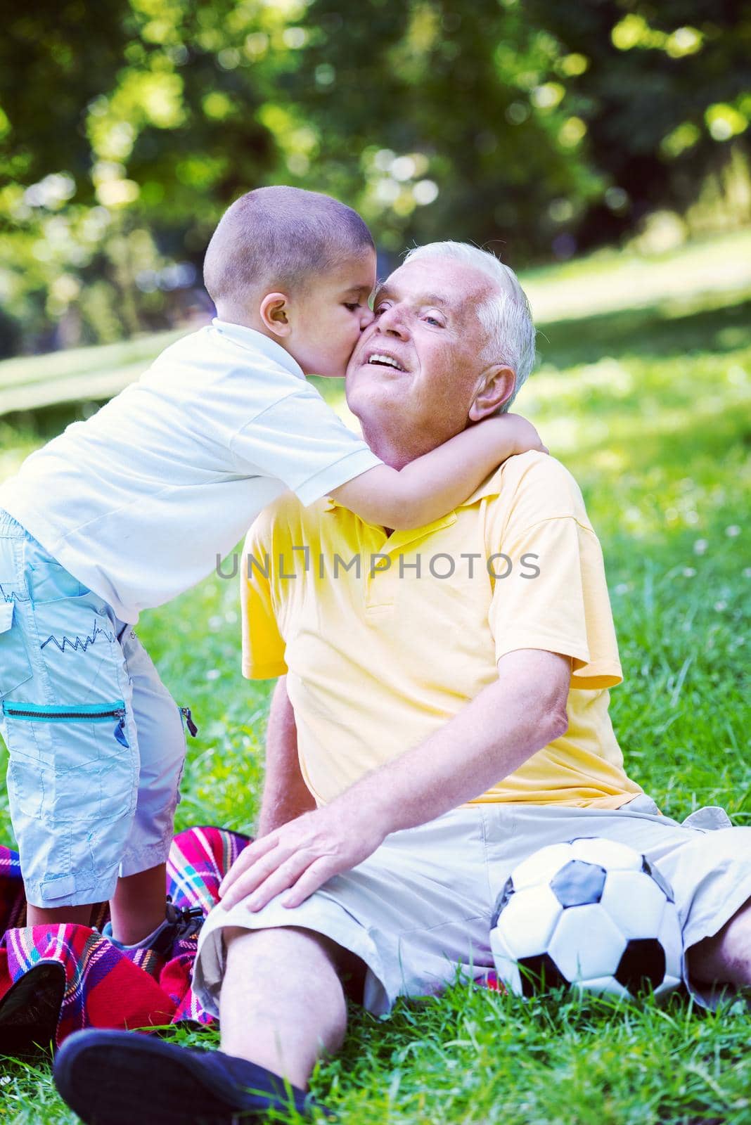 happy grandfather and child have fun and play in park on beautiful  sunny day