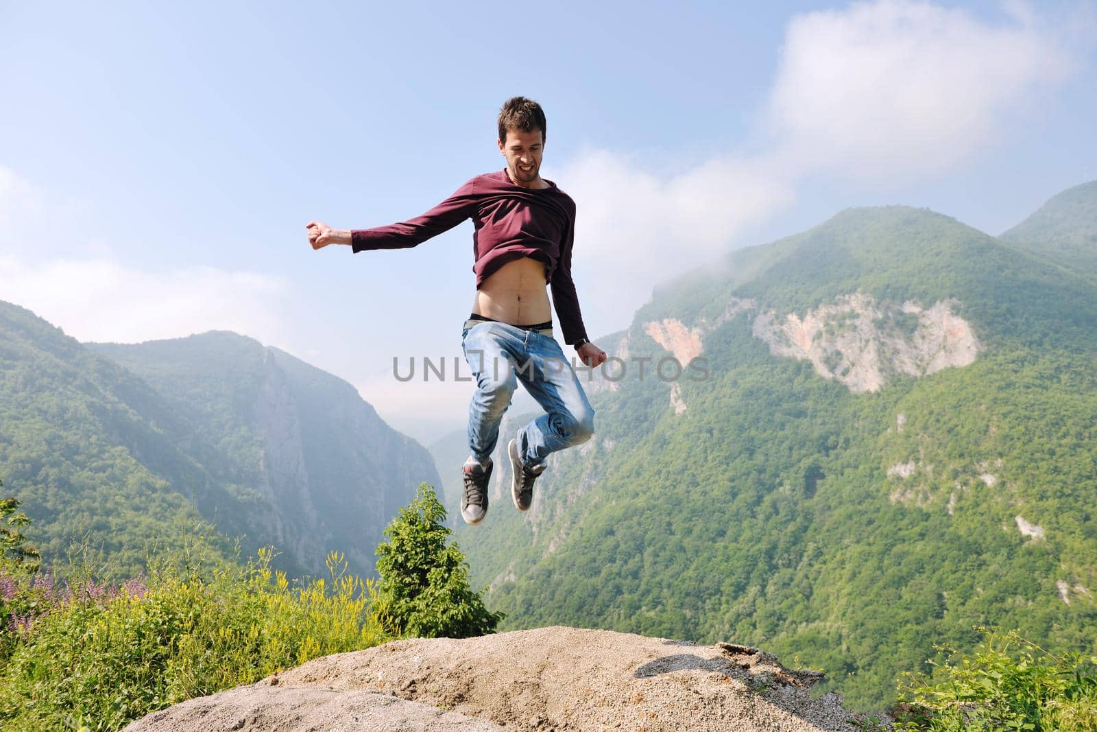 happy young man jump in nature while representing healthy lifestyle freedom and active concept