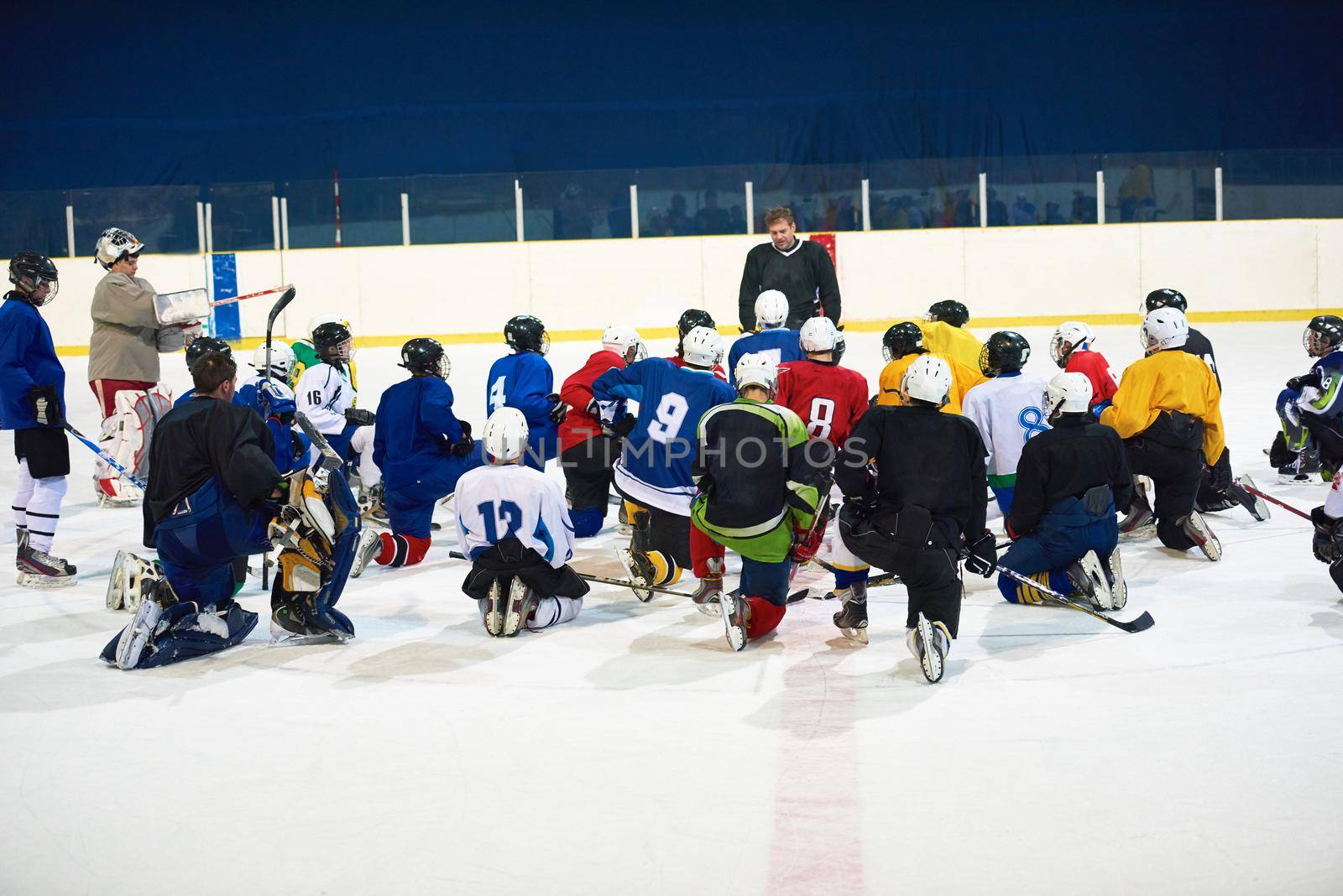 ice hockey players team group meeting with trainer  in sport arena indoors