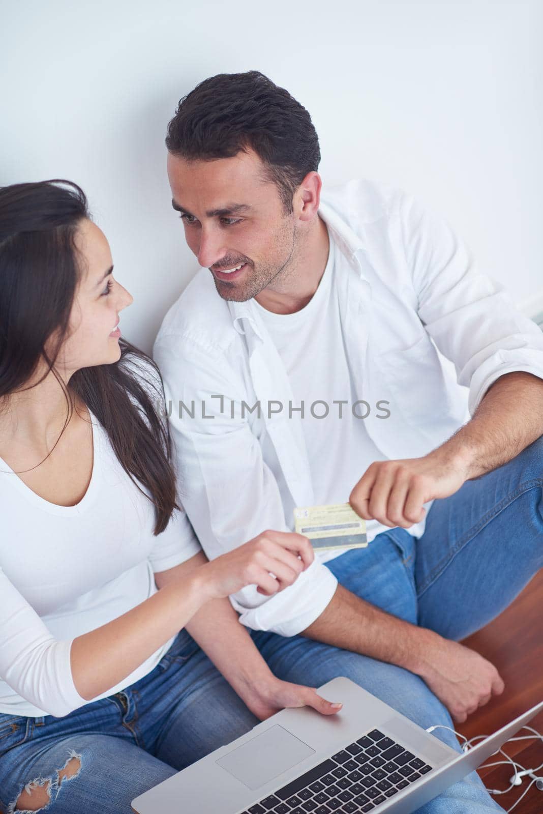 happy young relaxed  couple working on laptop computer at modern home interior