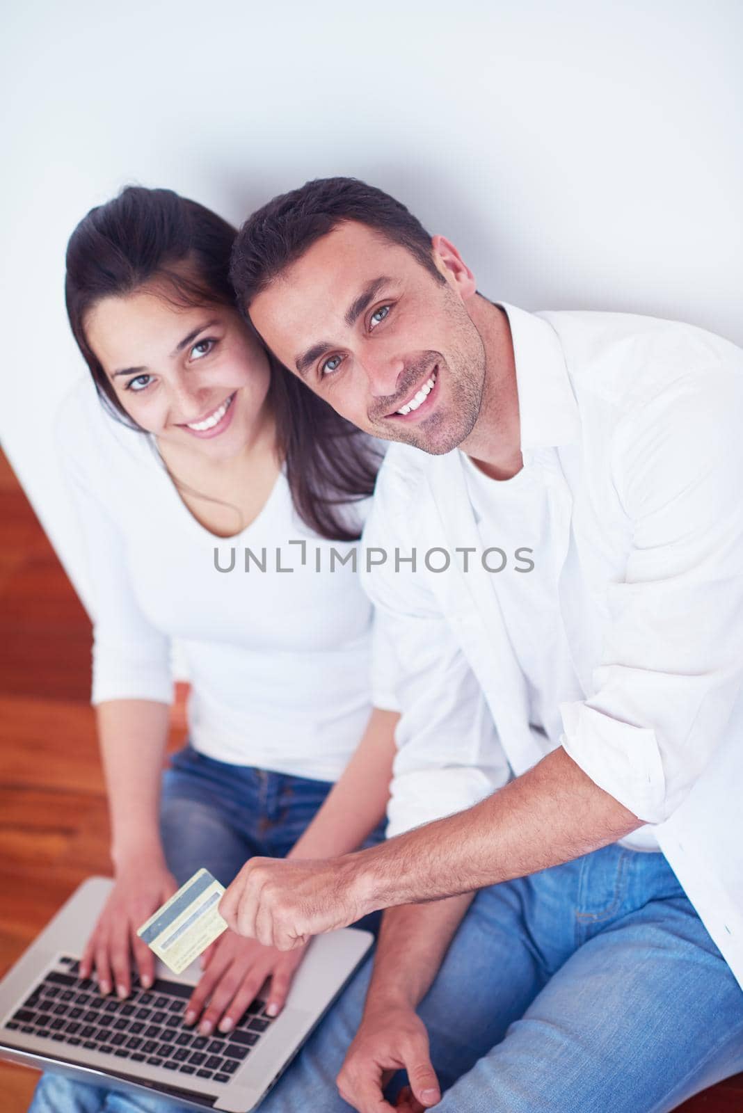happy young relaxed  couple working on laptop computer at modern home interior