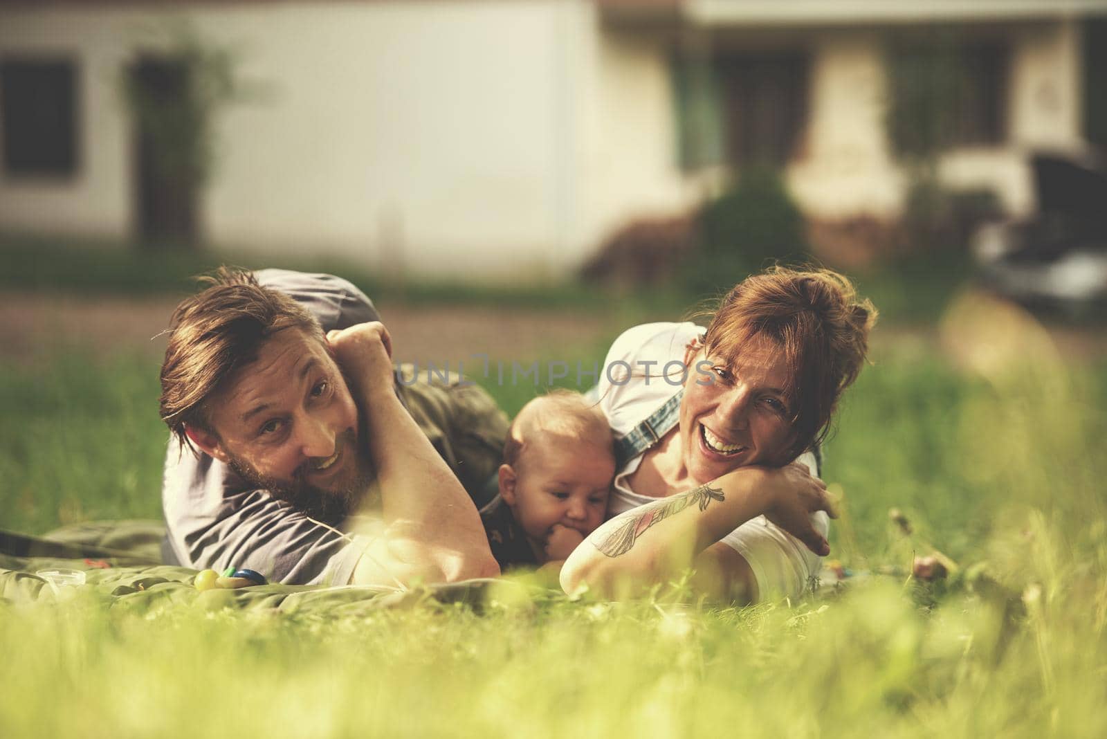 hipster family relaxing in park and playing with baby on beautiful sunny spring day