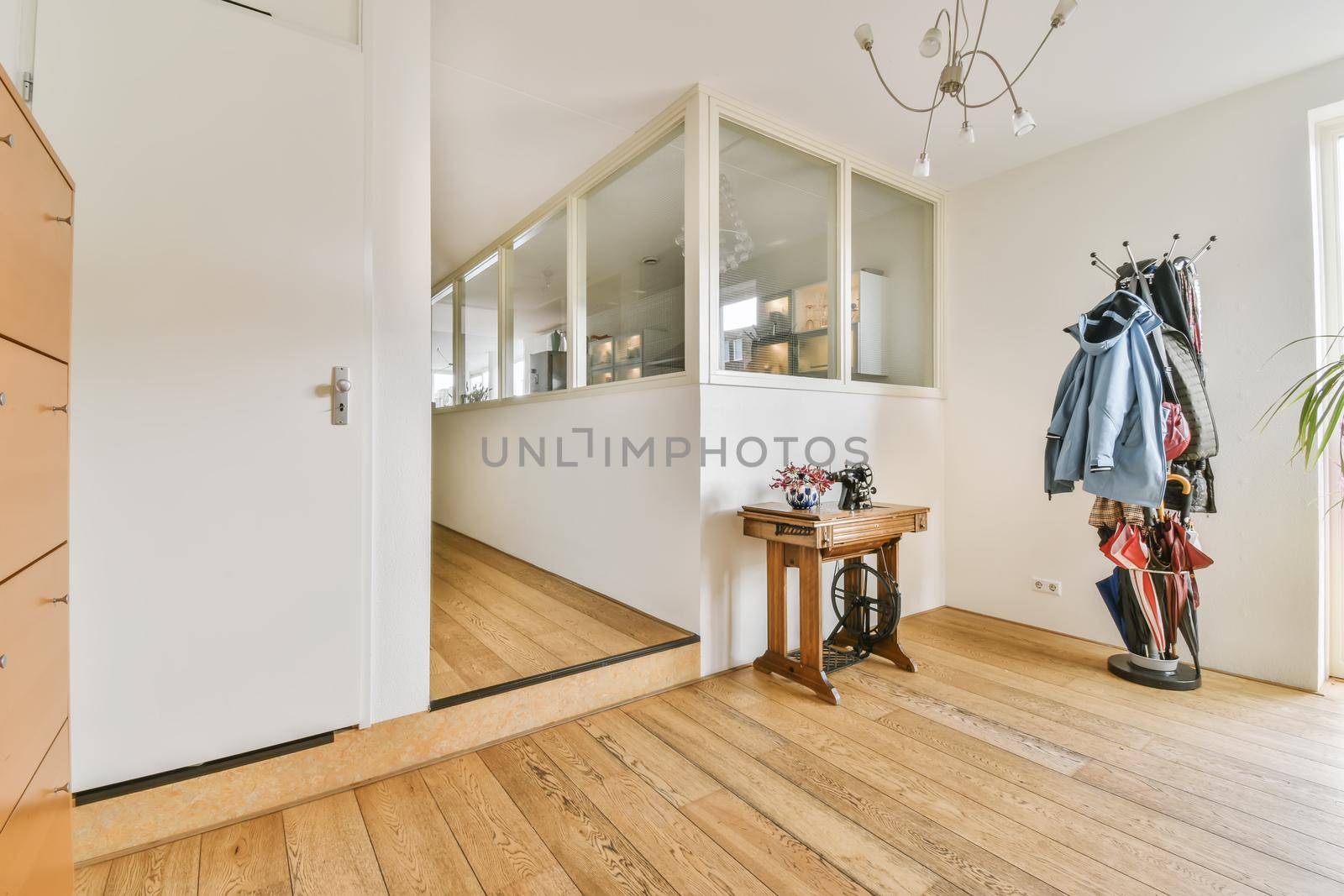 An adorable spacious hallway with a coat rack and a small wooden table