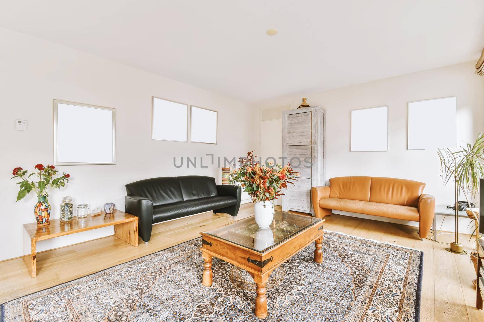 Lovely living room with black leather sofa and wooden coffee table
