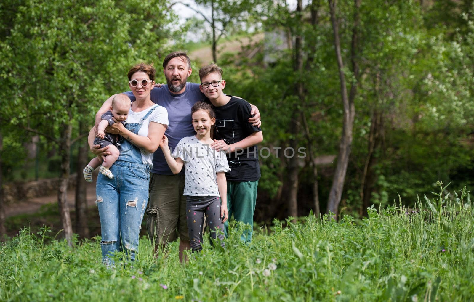 portrait of happy young big hipster family while  having picninc and fun time in nature