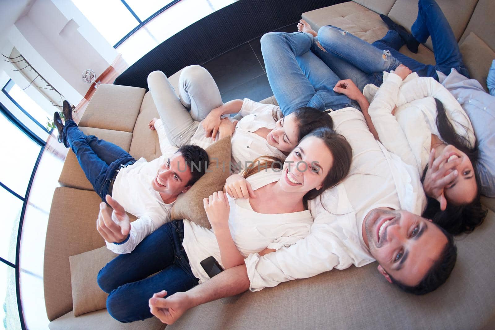 portrait of happy young group of friends get releax and have fun at modern home interior, top view