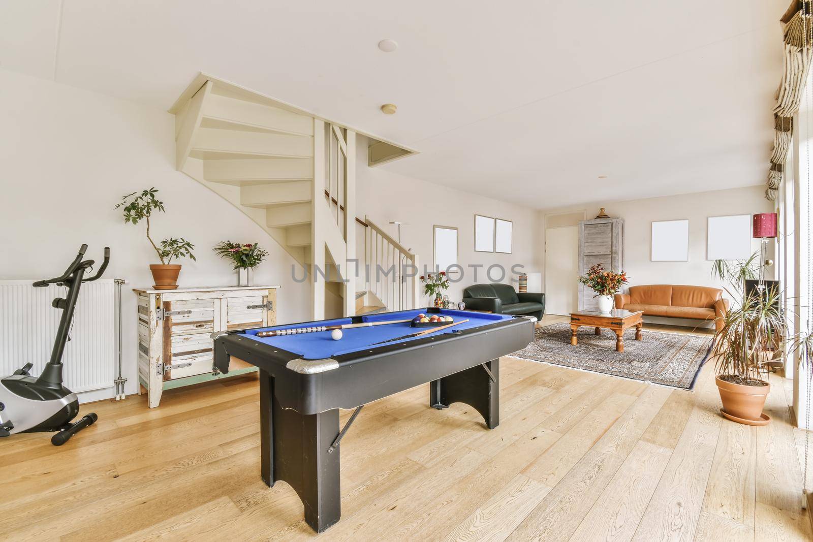 Lovely living room with black leather sofa and pool table