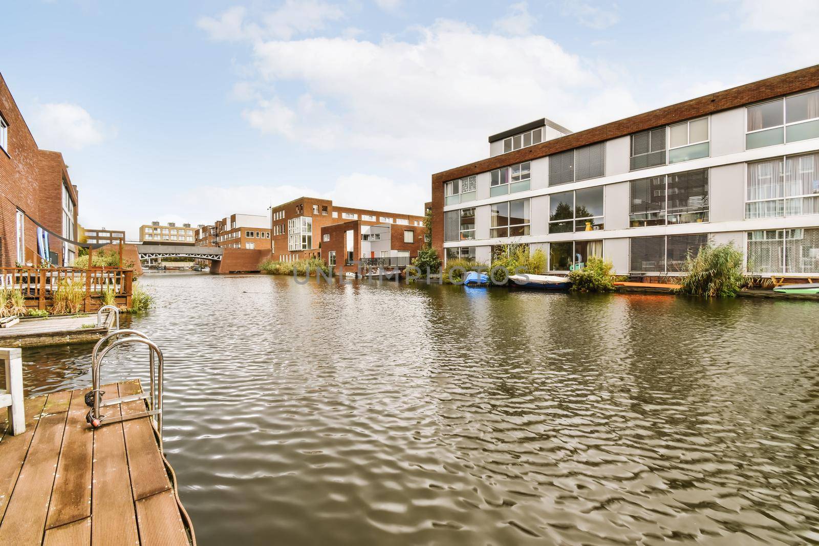 Adorable wooden boathouse in front of brick houses