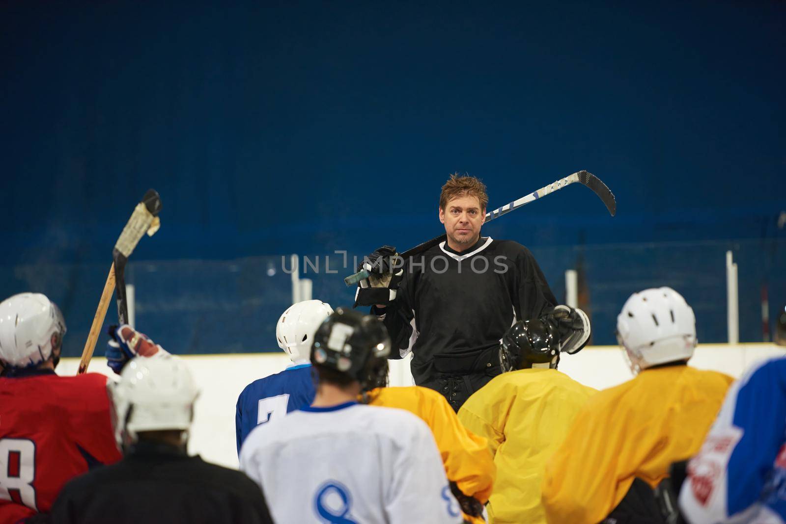 ice hockey players team group meeting with trainer  in sport arena indoors