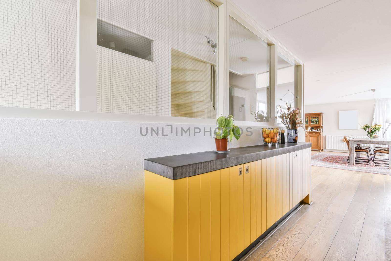 A lovely corridor with a yellow cabinet and a flower in a pot