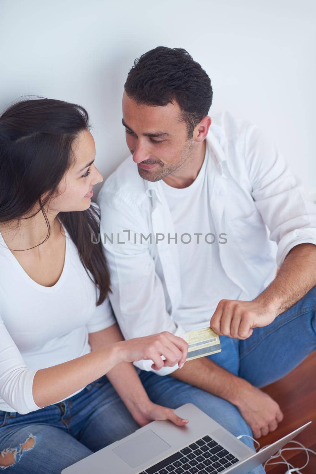 happy young relaxed  couple working on laptop computer at modern home interior